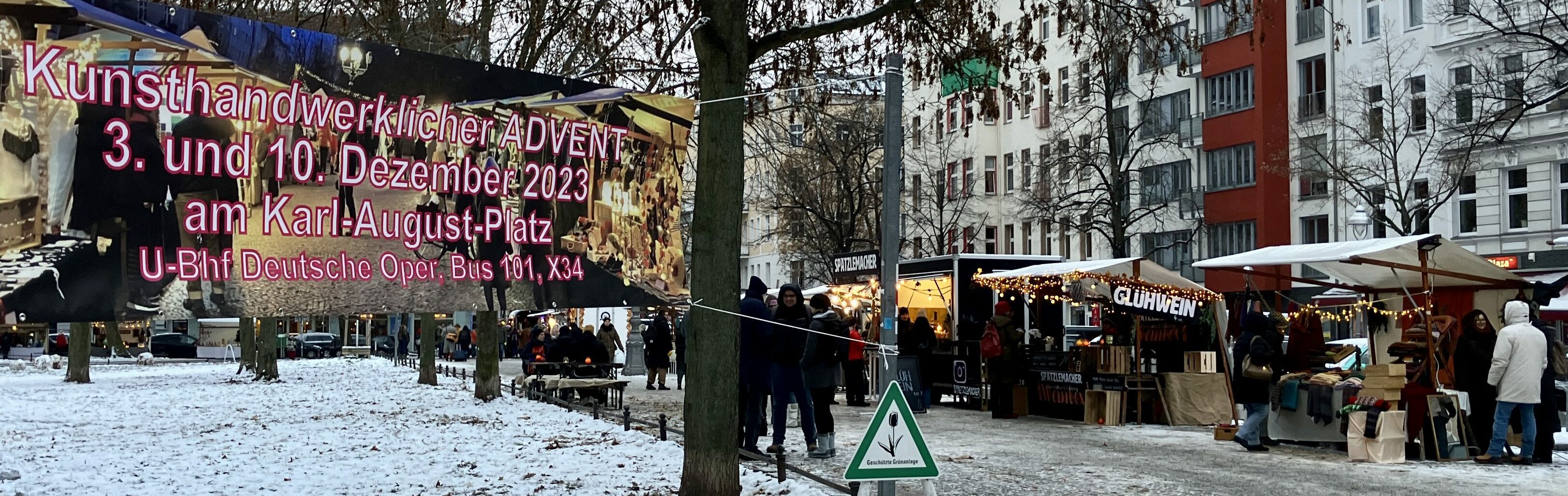 Das Transparent zum Kunsthandwerklichen Advents-Weihnachtsmarkt am 3. und 10. Dezember 2023 auf dem Karl-August-Platz sowie ein paar Stände wie Glühwein und Spätzle.