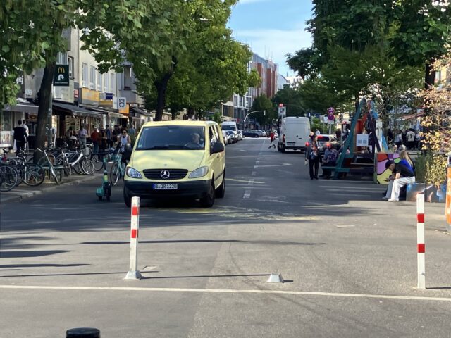 Ein Kleinbus fährt durch die Fußgängerzone.