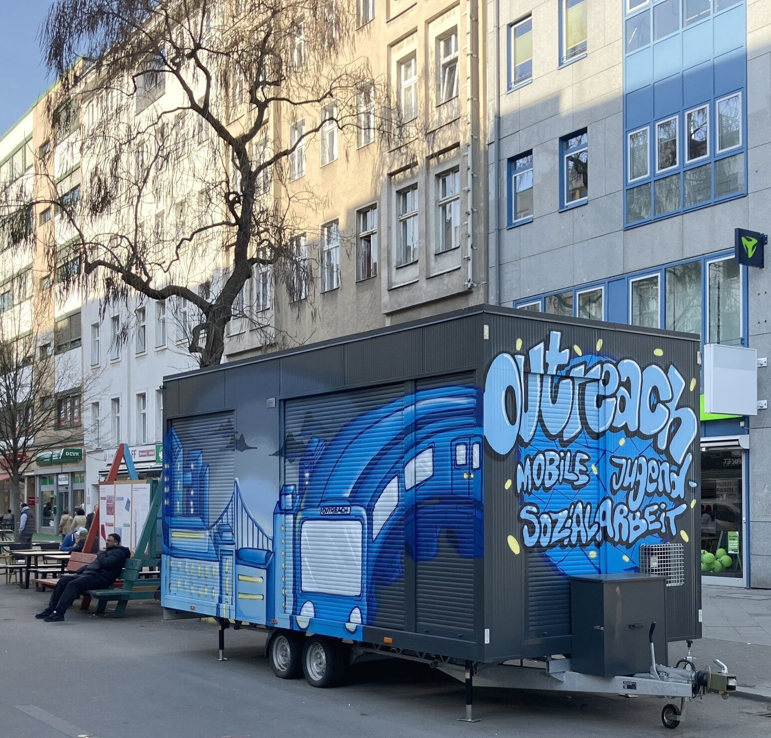 Ein geschlossener Event-Anhänger mit der Aufschrift „Outreach“.